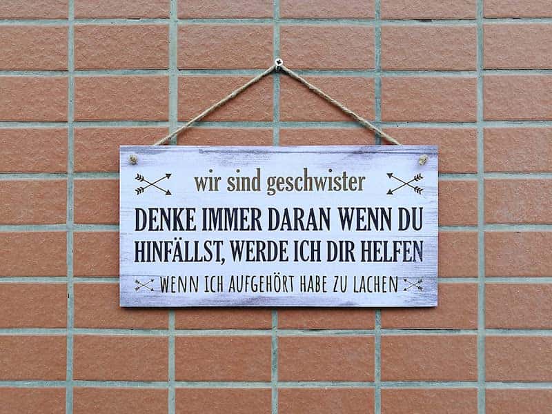 Schild mit Spruch zu Geschwistern an einer Wand