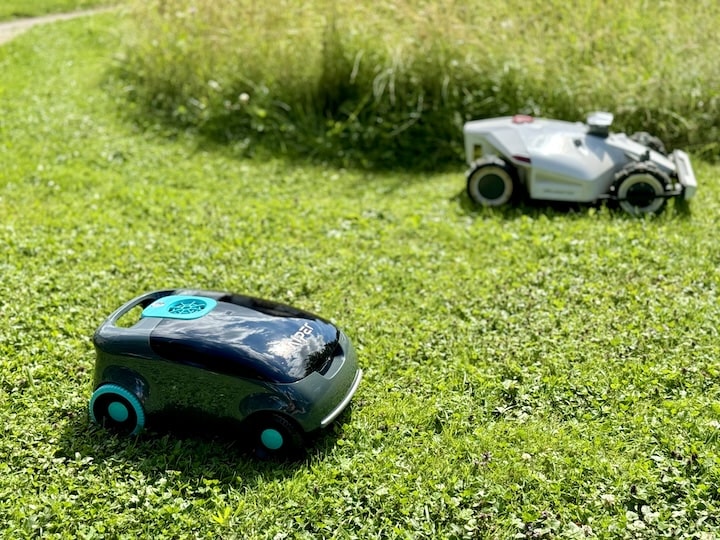 Poolroboter und Maehroboter auf einer Wiese